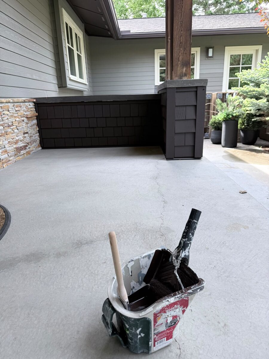 Exterior trim painting in progress with brush and tools