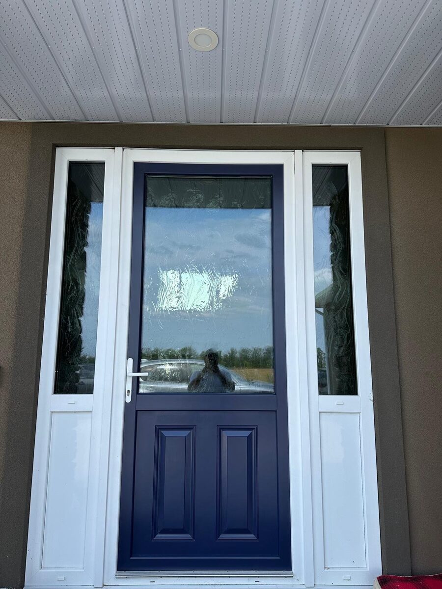 Exterior entry door painted navy blue, finished